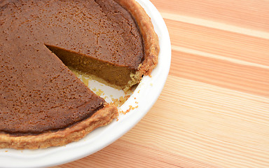 Image showing Close-up of cut pumpkin pie with slice taken