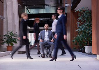 Image showing business man sitting in office chair, people group  passing by