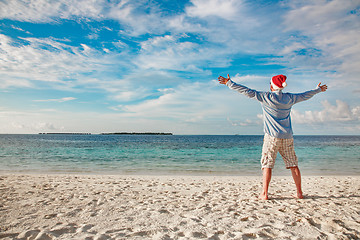 Image showing Man in santa hat on the tropical beach