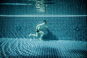 Image showing Man runs underwater swimming pool