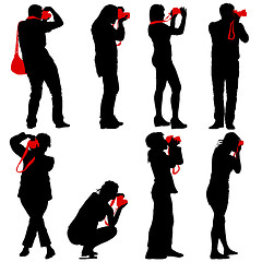 Image showing Cameraman with video camera. Silhouettes on white background. 