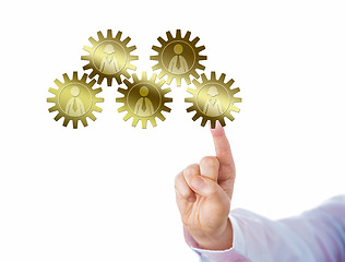 Image showing Hand Touching A Golden Gear Train Of Five Workers