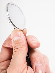 Image showing Closeup of hand holding a stethoscope towards bright background