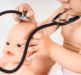 Image showing Toddler running a health check on a hairless doll with a stethos