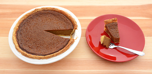 Image showing Pumpkin pie for Thanksgiving with a slice on a plate