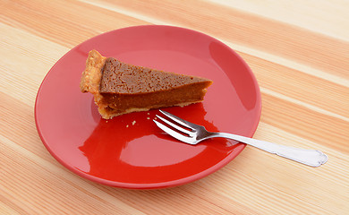 Image showing Slice of pumpkin pie with a fork on a plate