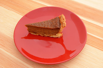 Image showing Red plate with a slice of pumpkin pie