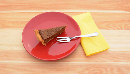 Image showing Slice of pumpkin pie on a red plate