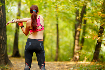 Image showing woman runner stretching before her workout