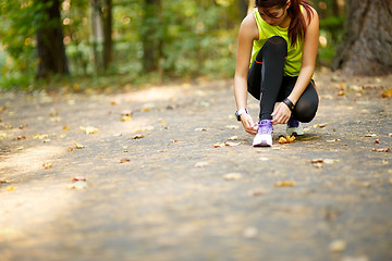 Image showing woman runner tying shoelaces