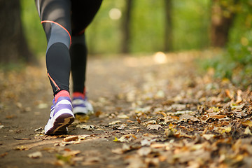 Image showing Runner feet running on road