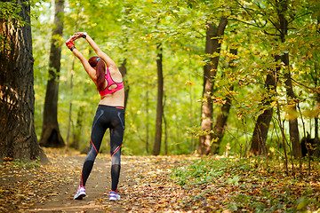 Image showing woman runner stretching before her workout