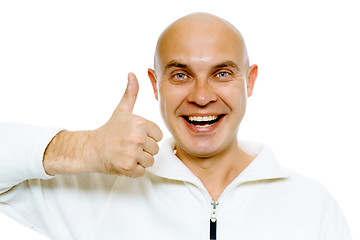 Image showing Bald smiling blue-eyed man with thumb up. Studio. isolated