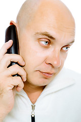 Image showing Bald, blue-eyed man with a telephone. Studio. isolated