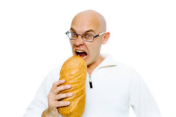 Image showing Hungry bald man bites a a large loaf. Studio. isolated