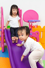 Image showing Asian Chinese little sister and brother playing on the slide