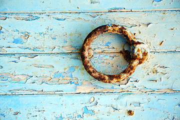 Image showing rusty  paint in the blue wood door and morocco knocker