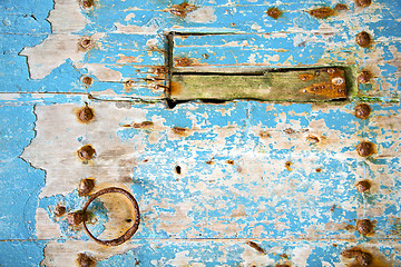 Image showing rusty   paint in the blue wood door and morocco knocker