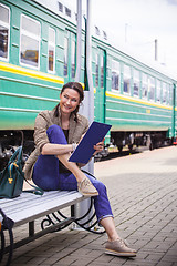 Image showing smiling woman is planning railway retro-travel