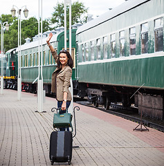 Image showing smiling beautiful middle-aged woman with a suitcase and handbag