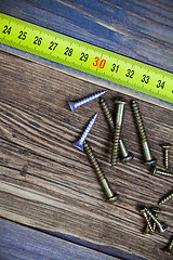 Image showing several different screws and yellow measuring tape