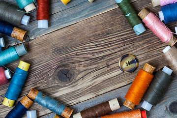 Image showing one vintage button and coils of different threads