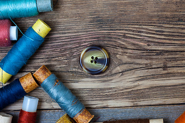Image showing old button and spools with threads