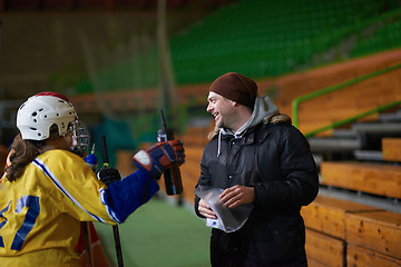 Image showing teen ice hockey players team meeting with trainer