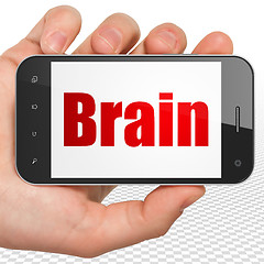 Image showing Healthcare concept: Hand Holding Smartphone with Brain on display