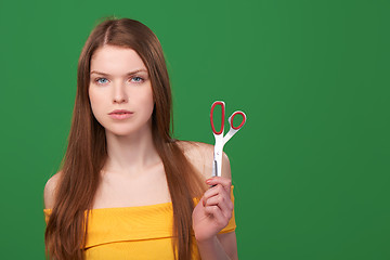 Image showing Calm redhead woman holding scissors