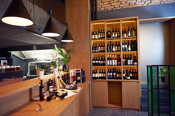 Image showing Wine bottles on a wooden shelf.