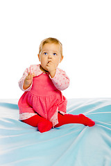 Image showing Beautiful baby sitting on a blue blanket. Studio