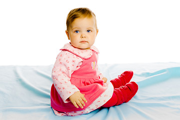 Image showing Beautiful baby sitting on a blue blanket. Studio