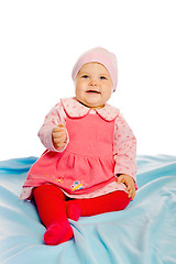 Image showing Beautiful baby sitting on a blue blanket. Studio