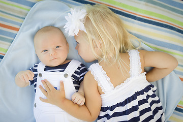 Image showing Little Sister Laying Next to Her Baby Brother on Blanket