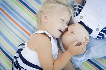 Image showing Little Sister Laying Next to Her Baby Brother on Blanket
