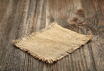 Image showing burlap napkin on wooden table