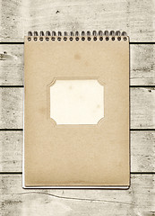 Image showing Closed spiral Note book on a white wood table