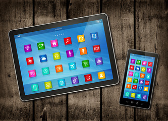 Image showing Smartphone and digital tablet PC with desktop icons on a dark wo