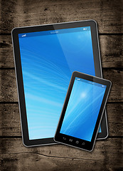 Image showing Smartphone and digital tablet PC on a dark wood table