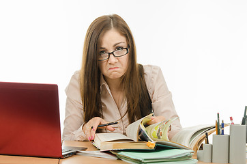 Image showing Frustrated teacher is looking for something in a book