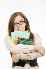 Image showing Thoughtful teacher with textbooks and notebooks