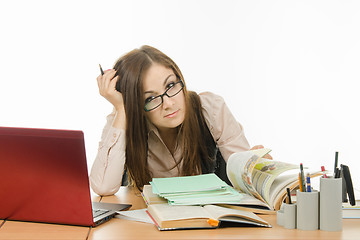 Image showing Master delves into the book, checking a notebook students