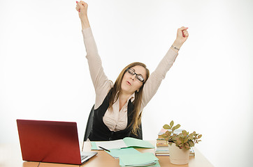 Image showing Teacher stretches sitting at your desk