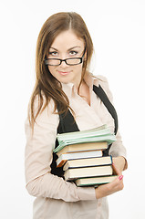 Image showing Portrait of a teacher with a heap of textbooks and notebooks