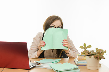 Image showing The teacher covered his face with a notebook