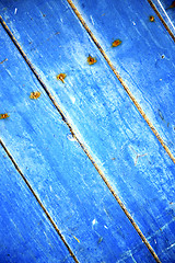 Image showing dirty stripped  in the blue wood door and rusty nail