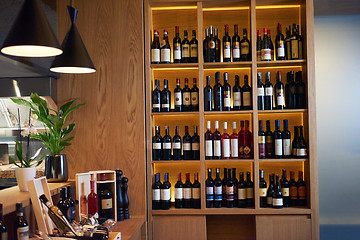 Image showing Wine bottles on a wooden shelf.