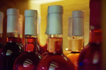 Image showing Wine bottles on a wooden shelf.