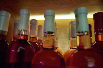 Image showing Wine bottles on a wooden shelf.